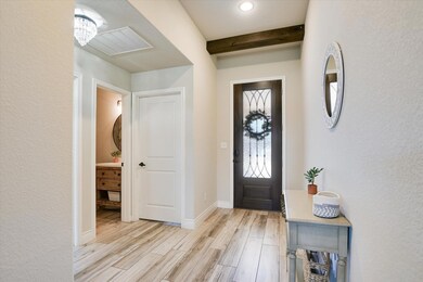 Entryway with light wood-style floors, beamed cei