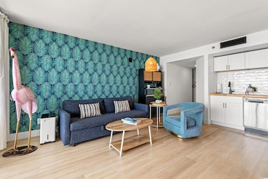 Living area featuring an accent wall, wallpapered walls, light wood-type flooring, and wet bar