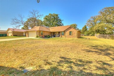 Ranch-style home featuring a front yard and a gara