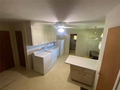 Washroom featuring cabinet space, a ceiling fan, and washer and dryer