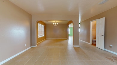 Living area near entryway leading into dining area.