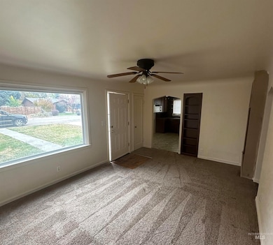 Unfurnished living room with arched walkways, carpet, and ceiling fan