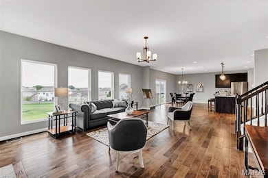 Living room with stairway, dark wood-style floors, a chandelier, and recessed lighting