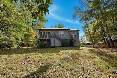 Front view of property featuring stairs, a metal roof, and a wooden deck