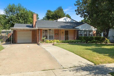 View of front of home with a garage and a front la