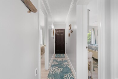 Hallway featuring crown molding and baseboards
