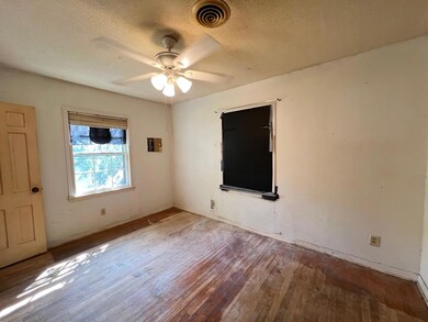 Empty room with a textured ceiling, ceiling fan, a