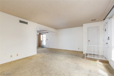 Empty room with visible vents, carpet floors, and