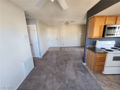 Kitchen featuring electric range, a ceiling fan, v