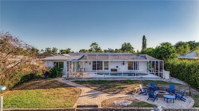 Back of property with glass enclosure, a fire pit,