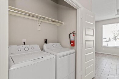 Laundry area featuring washing machine and clothes dryer and light tile patterned floors