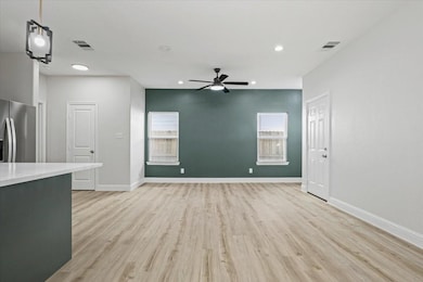 Unfurnished living room with ceiling fan and light