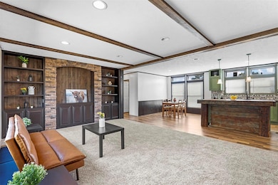 Living room featuring beam ceiling, built in featu