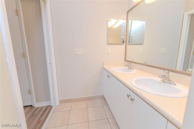 Full bath featuring double vanity, baseboards, and