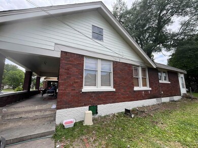 View of side of property with brick siding and a porch