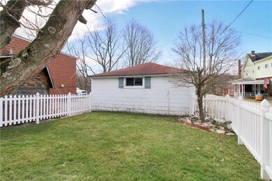 White picket fenced-in  level yard leads to 2 car