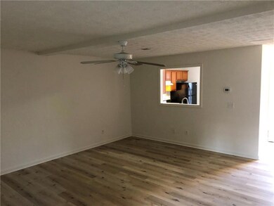 Spare room with wood finished floors, a ceiling fan, and baseboards