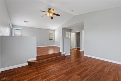 Primary bedroom with a ceiling fan, vaulted ceilin