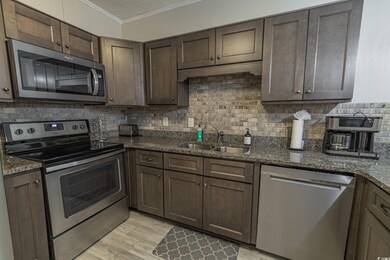 Kitchen featuring crown molding, backsplash, appli