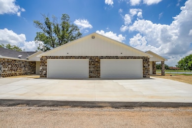 View of front of property with stone siding, a garage, and concrete driveway