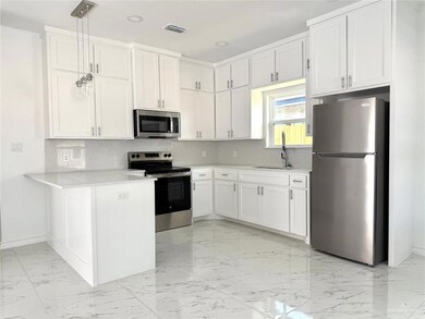 Kitchen with tasteful backsplash, stainless steel appliances, light marble finish floors, and recessed lighting