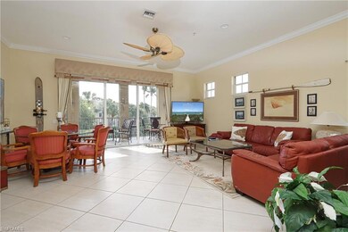 Living room featuring crown molding, healthy amount of natural light, light tile patterned flooring, and ceiling fan