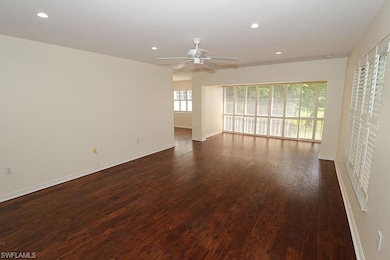 Unfurnished room featuring dark wood-type flooring and ceiling fan