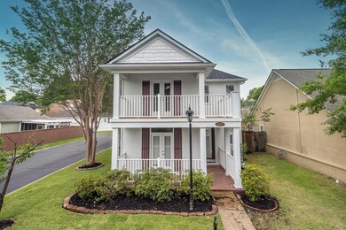 View of front of home with french doors, a balcony, and a porch