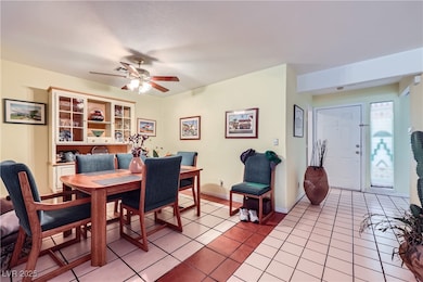 Dining space with ceiling fan and tile patterned f