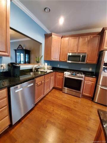 Gas range, stainless dishwasher, microwave, and refrigerator look great with the granite counter tops and the cherry cabinets.