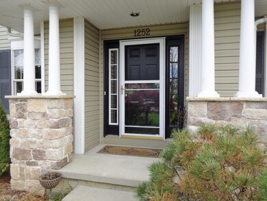 Graceful front stoop with stone facad and piullars