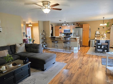 Living room with ceiling fan and light wood-style flooring