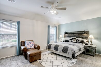 Enjoy plush carpeting in the primary bedroom suite with two large windows and painted accent wall.