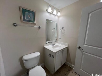 Bathroom with vanity, toilet, and tile patterned f