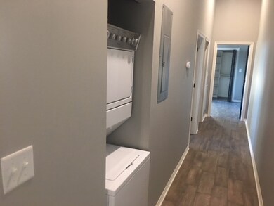 Hallway with stacked washer / drying machine, dark
