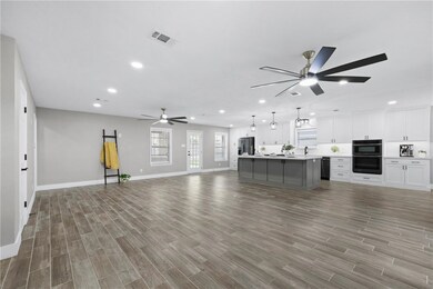 Unfurnished living room featuring wood finished fl