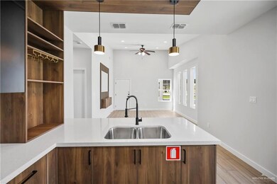 Kitchen featuring light wood finished floors, a sink, visible vents, and light countertops