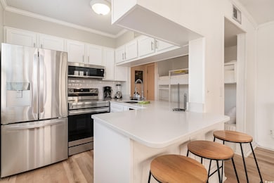 Kitchen with kitchen peninsula, light hardwood / w