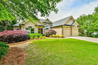 View of front facade featuring driveway, an attached garage, a front lawn, and stucco siding