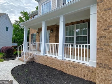 Entrance to property featuring covered porch and brick siding