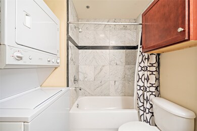 Stacked, full-size washer and dryer in the bathroo