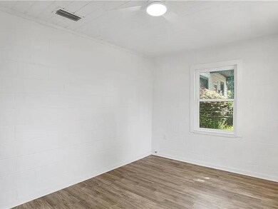 Unfurnished room with wood finished floors and concrete block wall