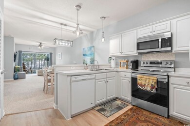 Kitchen with open floor plan, white cabinetry, sta
