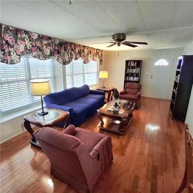 Living room with hardwood / wood-style flooring and ceiling fan
