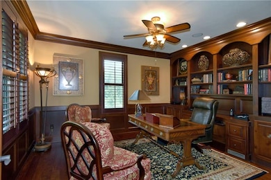 A judges paneled den with built-in shelving is loc