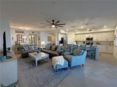 Living room with ceiling fan, sink, and light tile