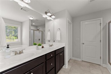 Full bath with a sink, baseboards, a shower stall,