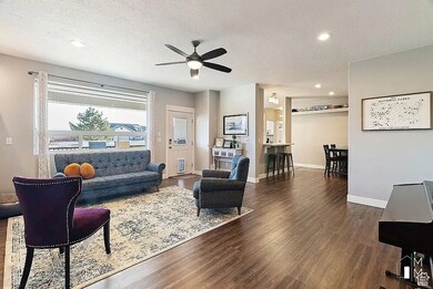 Living area featuring a textured ceiling, dark wood-style floors, ceiling fan, and recessed lighting