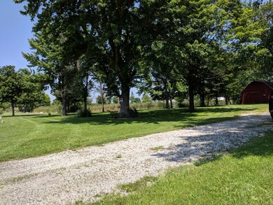 Driveway with pond to the left, house would be to 
