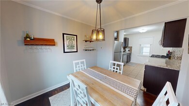 Dining area with light hardwood / wood-style floors and crown molding